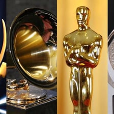 Award statues representing the Emmy, Grammy, Oscar, and Tony awards.