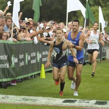 A runner crossing the finish line in second place.