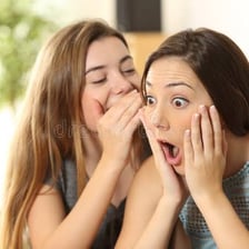 A person revealing a secret to surprised friends.