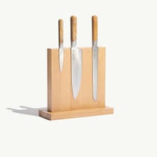 A small paring knife stored in a wooden knife block.