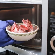 Frozen food thawing as it warms on a kitchen counter.