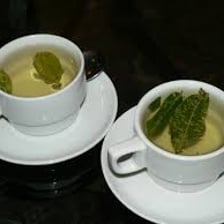 A cup of coca tea beside coca leaves