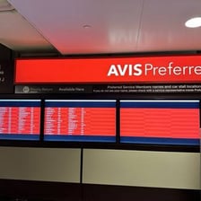 Avis rental cars parked near an airport rental facility