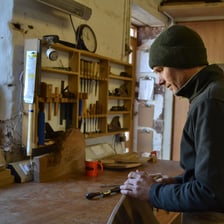 An artisan skillfully making an object by hand.