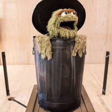 Oscar the Grouch, the green Sesame Street character who lives in a trash can.