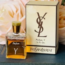 A Yves Saint Laurent logo displayed with a branded perfume bottle