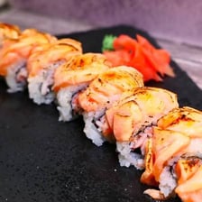 An Alaska sushi roll topped with slices of salmon
