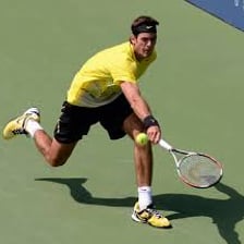 A tennis player hitting a high lob shot over an opponent.