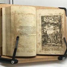 An open book displaying an old poetry text.
