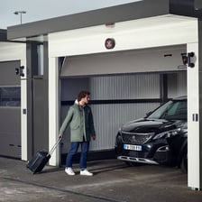 A parking valet standing beside cars at a hotel entrance