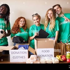 A person handing donated items to a charity worker