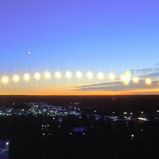 The Sun rising above a horizon in the east.