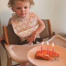 A child beside a birthday cake marked with the number six.