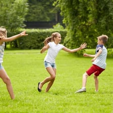 Children playing tag, with one child identified as “it.”
