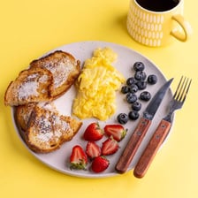 A brunch plate with eggs, toast, and coffee.