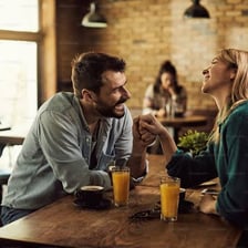 Two people engaging in a playful conversation at a cafe
