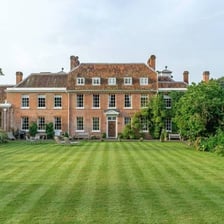 A large house set within broad landscaped grounds.