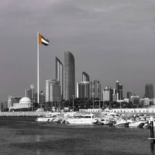 The United Arab Emirates flag with Abu Dhabi’s skyline in the background.