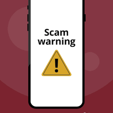 A phone displaying a warning about a possible scam