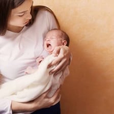An adult soothing a baby.