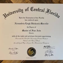A Master of Fine Arts diploma displayed near theater materials.