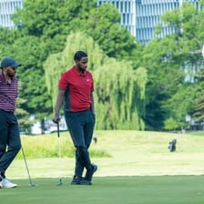 Golfers playing on a green golf course.