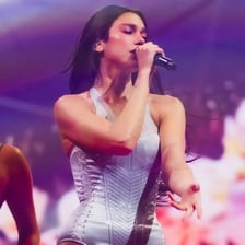 A portrait of singer Dua Lipa performing on stage.
