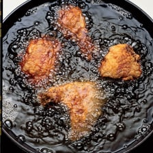 Food being deep-fried in a pot of hot oil.