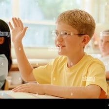 A child eagerly raising a hand to be selected.