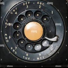A close view of the numbered rotating dial on a vintage telephone.