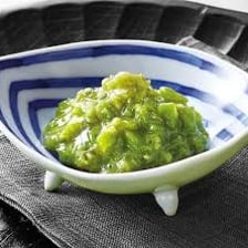 A mound of green wasabi paste in a small dish