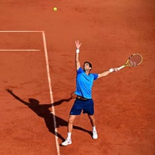 Tennis player beginning a point with a serve