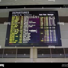 An airport departures board showing international flights from LAX.