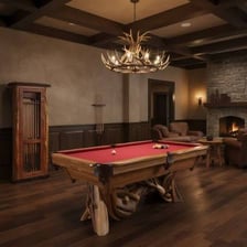 A billiards cue resting beside a pool table.