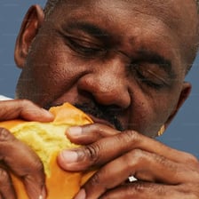 A person eating food quickly and enthusiastically.