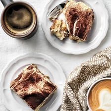 A slice of tiramisu showing its layered coffee-soaked interior and mascarpone topping.