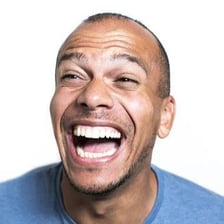 A person smiling while letting out a small chuckle