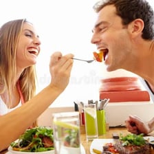 One person offering food to another person for tasting.