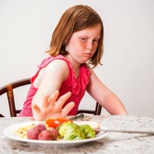 A person sampling a small bite of food
