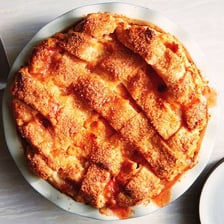 A peach pie with a woven lattice pastry crust.