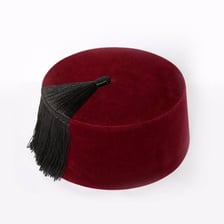 A traditional red fez with a black tassel beside Moroccan cultural imagery