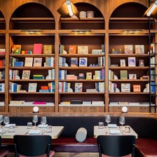 A café area inside a bookstore, with bookshelves and tables.