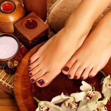 A salon worker applying polish during a pedicure.