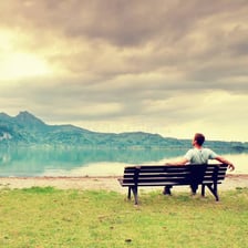 A person sitting alone in a quiet landscape.