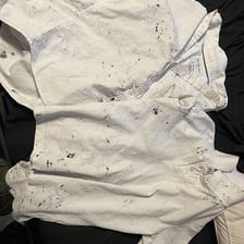 A dark ink stain spreading through light-colored fabric