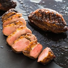 Chicken breast and duck breast portions on a cutting board.