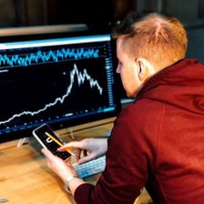 A person reviewing financial investments on a market screen