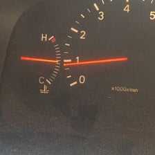 A car engine associated with an overheating temperature gauge and coolant