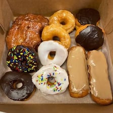 A box containing a dozen assorted doughnuts.