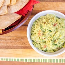 Tortilla chips served with a bowl of guacamole.